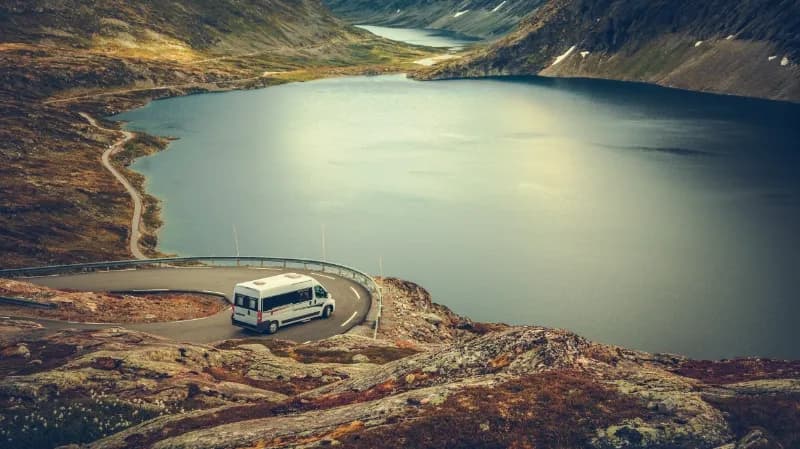 Ein Camper steht an einem Bergsee