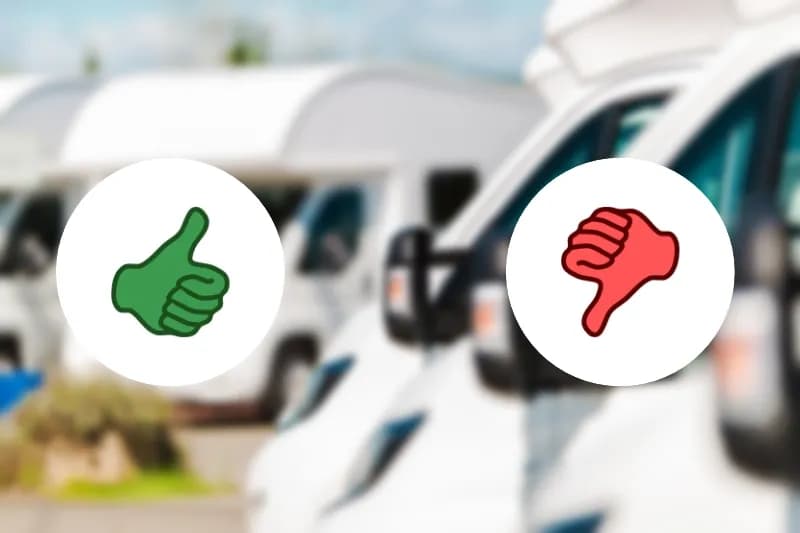 Im hintergrund verschwommen campingfahrzeuge. davor daumen nach oben und untern für vor- und nachteile